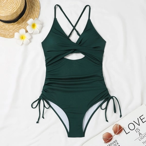 Close-up of dark green ribbed swimsuit with hollow-out knot and drawstring side details