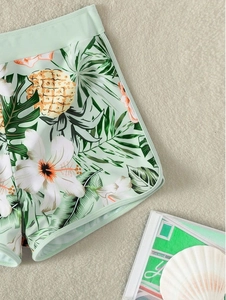 Dettaglio dello slip bikini verde menta con stampa tropicale di ananas e fiori