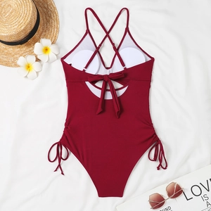 Detail of burgundy ribbed one-piece swimsuit with lace-up sides and cross back straps