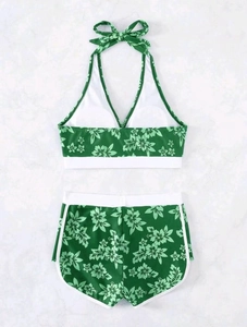 Detail eines zweiteiligen Bikinis mit tropischem Hibiskus-Druck und hoher Taille mit Schleife