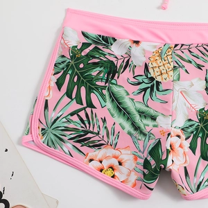 Slip bikini stile pantaloncino rosa con stampa tropicale e motivi di fiori e ananas