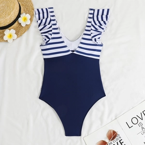 Flat lay of a one-piece swimsuit with blue-white stripes and ruffles on a white background