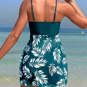 Teal tankini swimdress with tropical palm leaf prints on a sunny beach setting