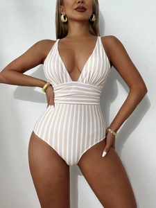 Detail of striped V-neck swimsuit with pleated waist and elegant gold accessories