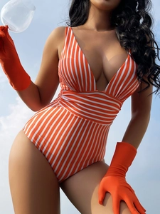 Close-up of orange and white striped V-neck swimsuit with matching long gloves against blue sky