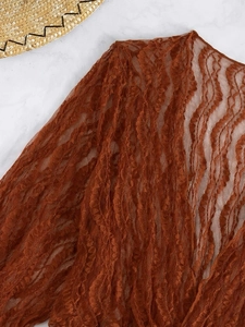 Dettaglio macro del tessuto a rete in pizzo ondulato arancione di altissima qualità