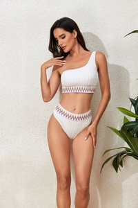 Detail of white one-shoulder bikini with colorful ethnic wavy embroidery and high waist
