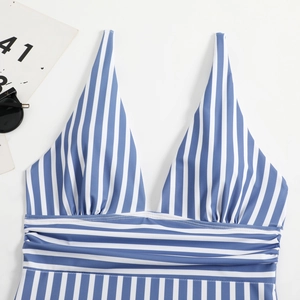 Detail of blue and white striped swimsuit featuring a deep V-neck and ruched fabric
