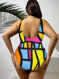 Rear view of plus size swimsuit featuring vibrant geometric color blocking and deep U-back