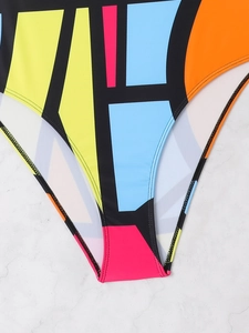Detailed close-up of high-elastic swimwear featuring bold geometric color-block patterns