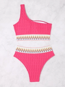 Detail of pink one-shoulder bikini featuring colorful zigzag elastic band and ribbed texture