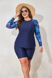 Detail of plus size long sleeve rash guard with tropical floral print and navy trunks