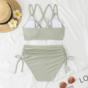 Detailed flat lay of sage green ribbed bikini with drawstring sides and cross-back straps