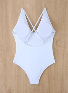 Detailed flat lay of white one-piece swimsuit featuring deep V-neck and crisscross back straps