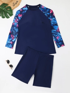 Close-up of long sleeve rash guard with tropical floral print and matching navy boyshorts