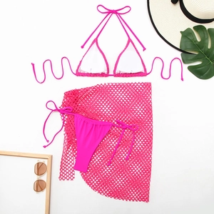 Flat lay of hot pink three-piece bikini set with a mesh beach skirt and summer accessories
