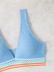 Detail of light blue smocked bikini top with colorful wavy crochet lace trim