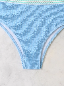 Close-up of light blue seersucker bikini bottom with wavy white and mint green trim