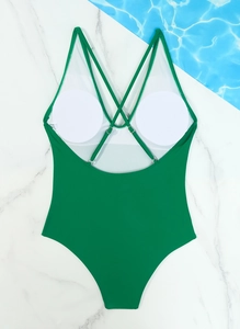 Detail view of green one-piece swimsuit back with crisscross straps and removable pads