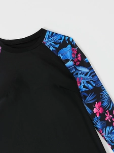 Detail of the tropical floral print on the shoulder and long sleeve of the rash guard