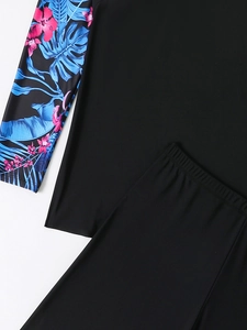 Detail of long sleeve swim top with vibrant tropical floral and leaf digital print