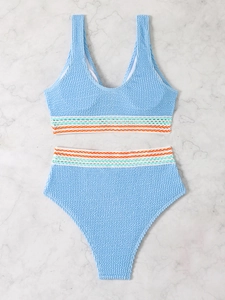 Close-up of light blue smocked bikini with colorful wavy trim and crinkled fabric texture