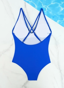 Detail view of royal blue one-piece swimsuit with cross-back straps and removable padding