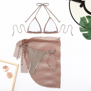 Flat lay of taupe three-piece bikini set with mesh skirt and summer beach accessories