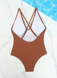 Detail of caramel one-piece swimsuit featuring adjustable cross-back straps and pads