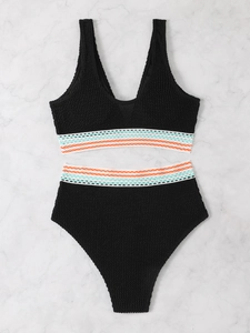 Macro shot of black high-waist bikini featuring textured fabric and wavy embroidery detail