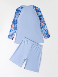 Close-up of long sleeve rash guard with tropical floral print and matching swim shorts