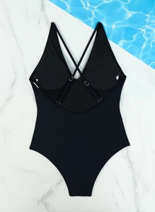 Detail view of black one-piece swimsuit with cross-back straps and padded chest