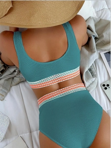 Detail view of high waist bikini with striped elastic bands and textured blue fabric