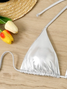 Detail showing metallic silver bikini top with drawstring and textured shiny fabric