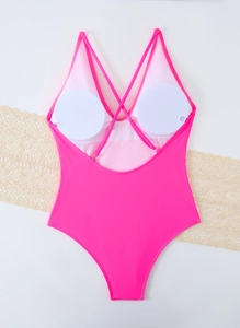Detail view of the pink one-piece swimsuit featuring cross back straps and removable pads