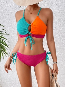 Close-up of color-block bikini with teal and orange halter top and textured fabric details