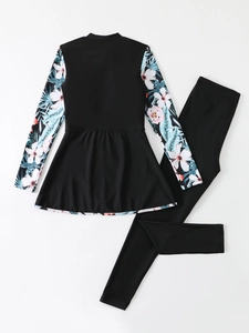 Detail view of long-sleeved swim top with tropical floral print and matching black pants