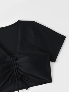 Détail du haut de maillot noir à col en V avec cordon de serrage et texture froncée