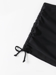 Détail du bas de bikini noir avec cordons de serrage réglables et tissu côtelé doux