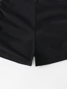 Gros plan du short de bain noir à taille haute avec coutures à double aiguille et détails