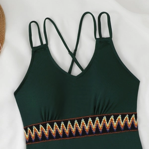 Detail of dark green ribbed swimsuit with ethnic embroidery and thin criss-cross straps