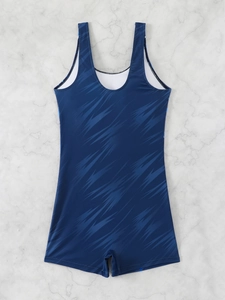 Flat lay of a navy blue one-piece boy-leg swimsuit with light blue abstract patterns