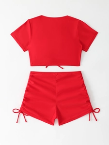 Détail du maillot de bain rouge deux pièces avec short à cordon et haut à manches courtes