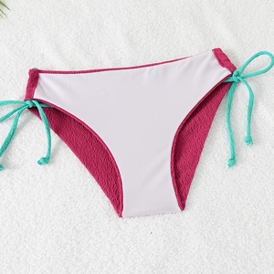 Detailed view of rose pink crinkle fabric bikini bottom with blue side ties and white panels