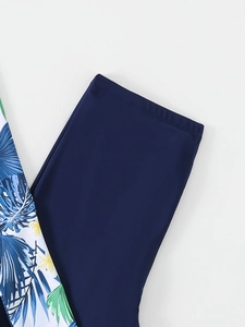 Detail view of navy swimsuit leggings with flatlock seams and tropical floral print panels