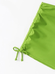 Détail du cordon latéral et des fronces réglables sur ce short de bain de couleur vert herbe