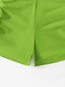 Gros plan détaillé du bas de maillot vert fruit montrant le tissu élastique et coutures
