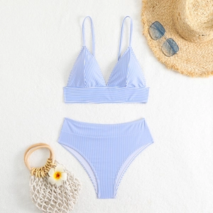 Detailed flat lay of blue and white striped high waisted bikini with vacation accessories
