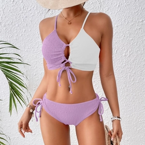 Detail of color-block bikini top with criss-cross straps and textured purple fabric