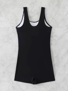 Detail view of the deep U-shaped back and purple floral lining on the black swimsuit